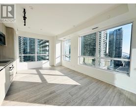 A spacious, well-lit living room with a view of the city skyline.