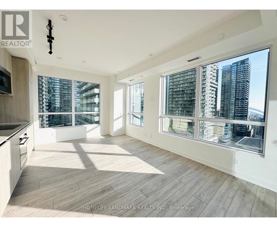 A spacious, well-lit living room with a view of the city skyline.