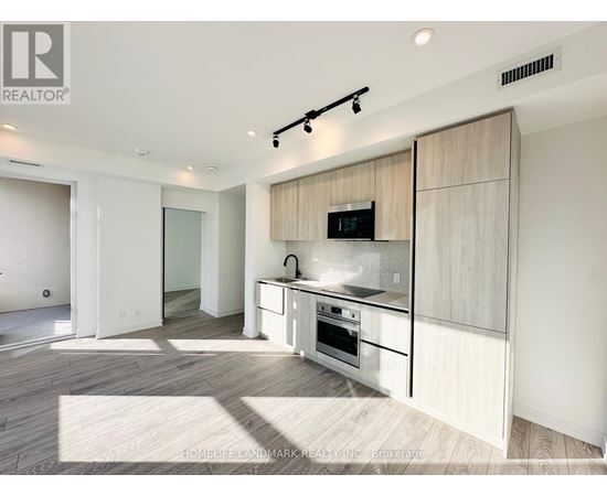 A modern kitchen with a white countertop and a microwave built into it.