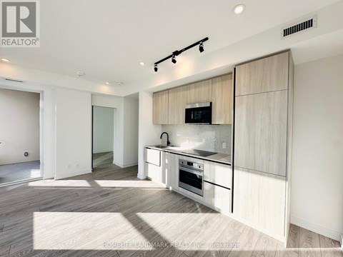 A modern kitchen with a white countertop and a microwave built into it.