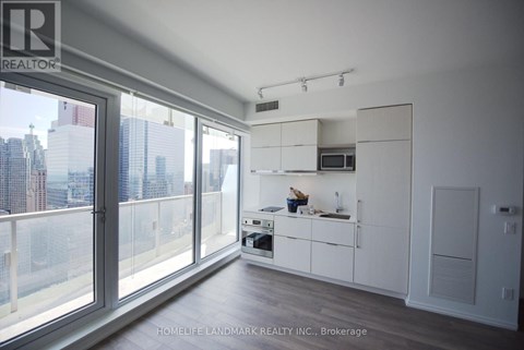 A modern kitchen with white cabinets and a view of the city.