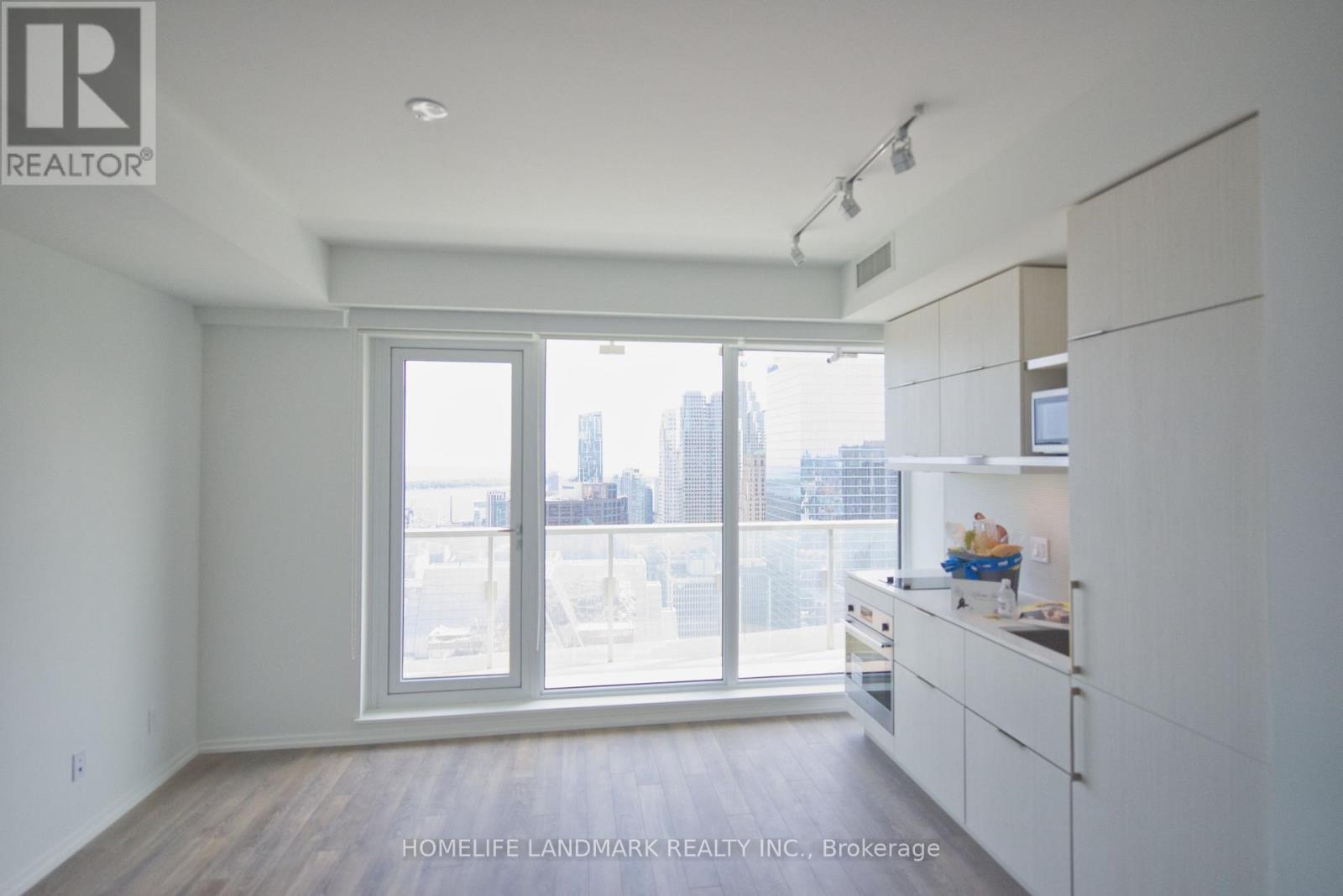 A spacious, empty room with a view of the city through the windows.