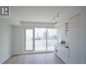 A spacious, empty room with a view of the city through the windows.