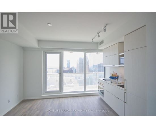 A spacious, empty room with a view of the city through the windows.