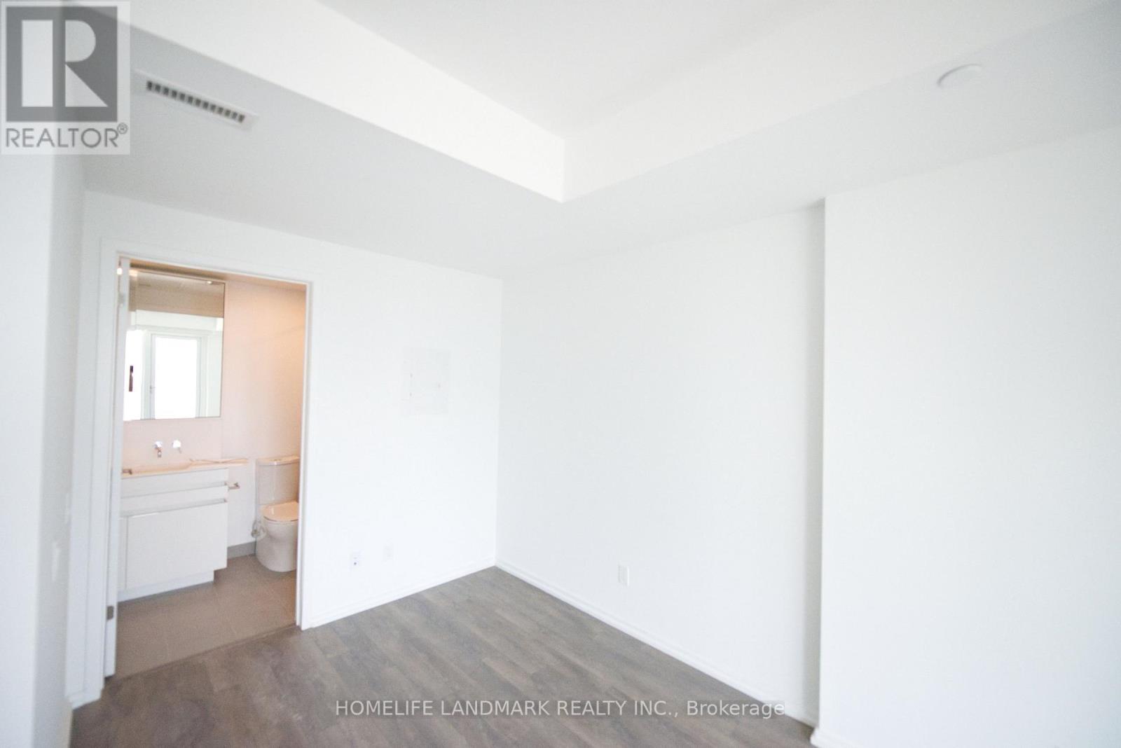 A white room with a bathroom visible through the door.