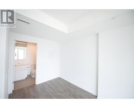 A white room with a bathroom visible through the door.