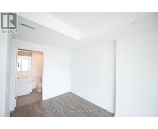A white room with a bathroom visible through the door.
