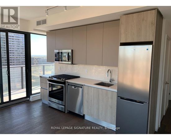 A modern kitchen with stainless steel appliances and wooden cabinets.