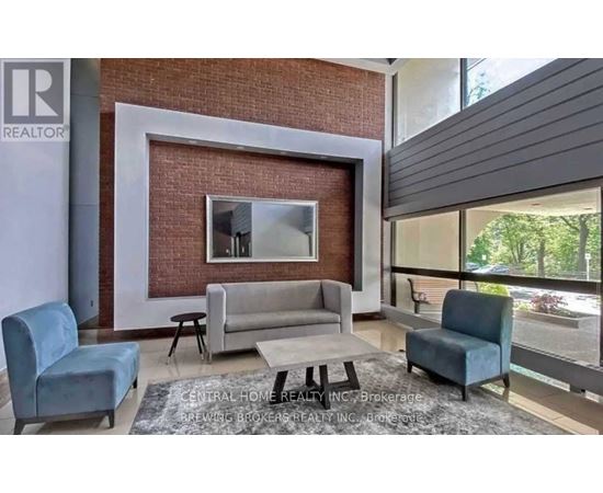 A living room with a grey couch and a white coffee table.