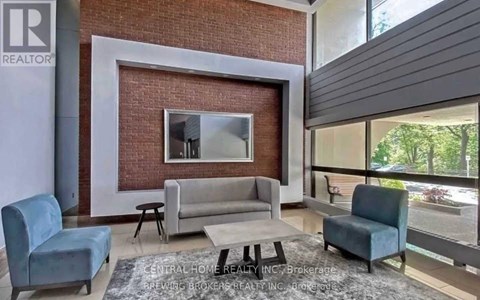 A living room with a grey couch and a white coffee table.