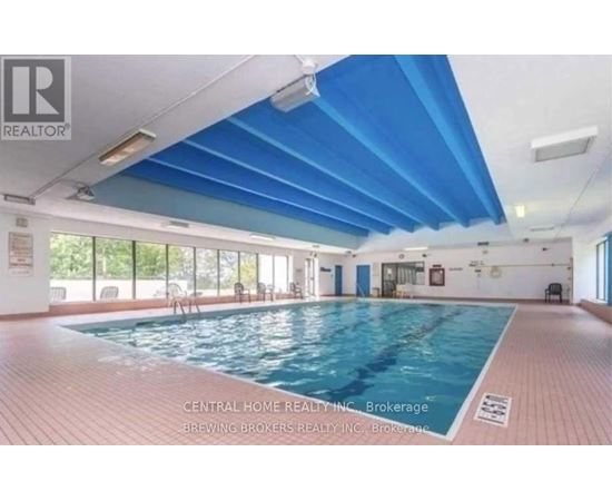 A swimming pool inside a building with a ceiling of blue panels.