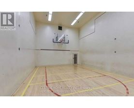 A gym with a basketball hoop and a wooden floor.