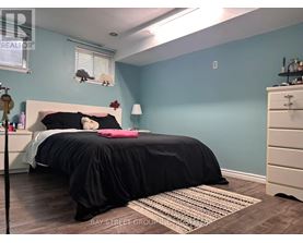 A bedroom with a bed, nightstand, and a rug.