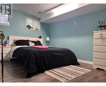 A bedroom with a bed, nightstand, and a rug.
