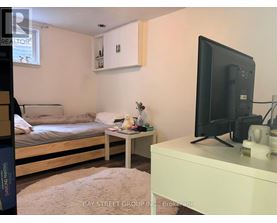 A bedroom with a bed, a small table, and a television.