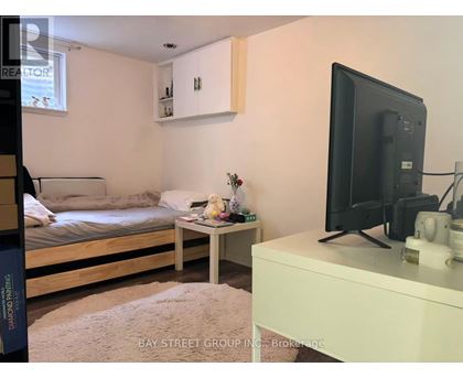 A bedroom with a bed, a small table, and a television.