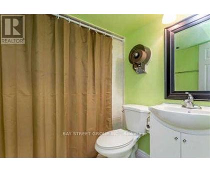 A small bathroom with a toilet, sink and shower curtain.