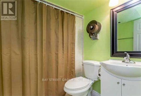 A small bathroom with a toilet, sink and shower curtain.