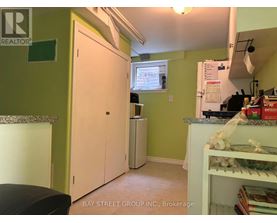 A kitchen with green walls and a white fridge.