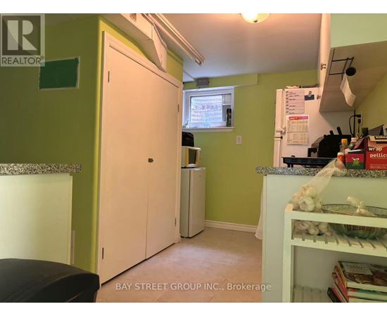 A kitchen with green walls and a white fridge.