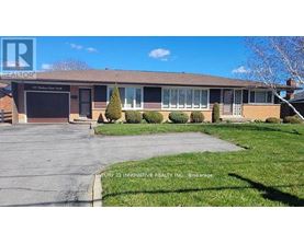 A realtor photo of a brick house with a garage.