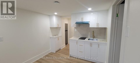 A white kitchen with a sink and cabinets.