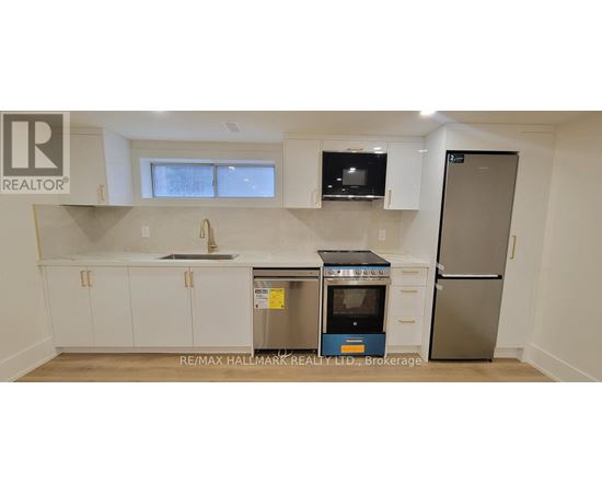 A kitchen with white cabinets and a stainless steel refrigerator.