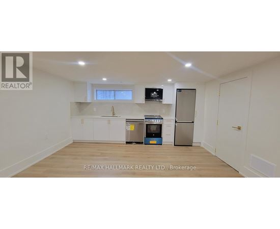 A white kitchen with a refrigerator, microwave, and oven.