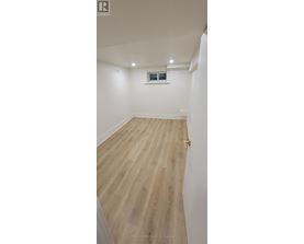 A room with wooden flooring and white walls.