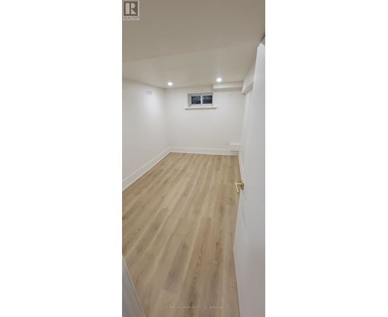 A room with wooden flooring and white walls.