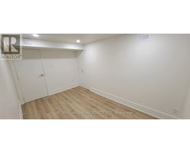 A white bedroom with a wood floor and a white closet.