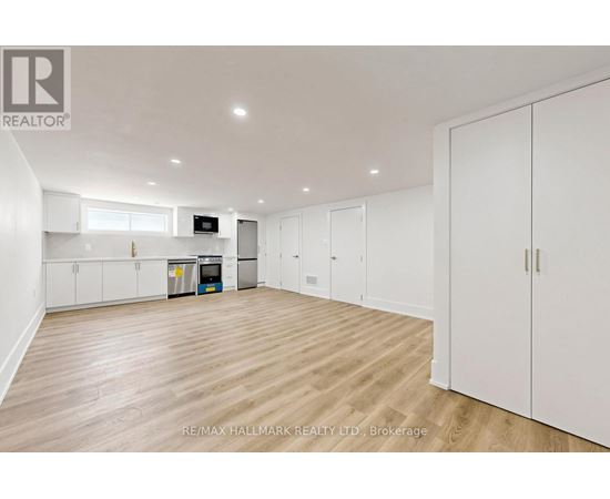 A white bedroom with a wood floor and a white closet.