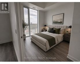 A bedroom with a large bed and a view of the city through the window.