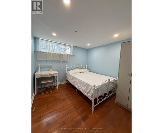 A bedroom with a bed, desk, and chair.