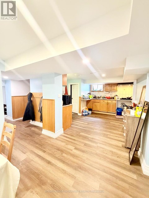 A kitchen with wooden floors and a dining area with a table and chairs.