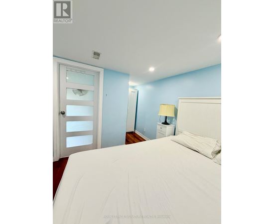 A bedroom with a white bed and a white door.