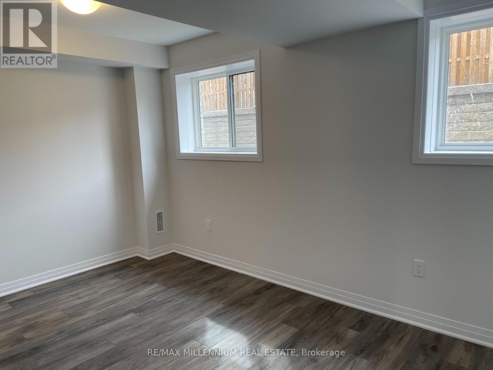 A room with a window and a wooden floor.