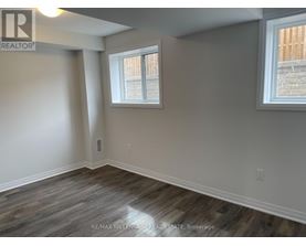 A room with a window and a wooden floor.