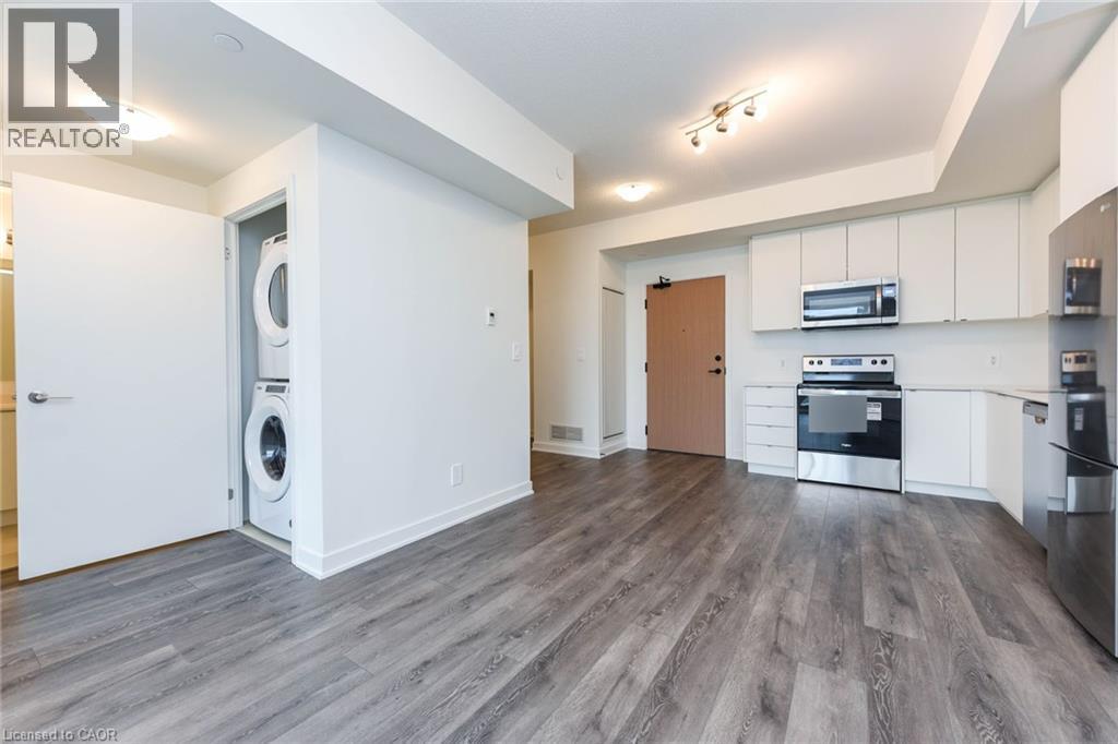 A modern kitchen with white cabinets and a wooden door.