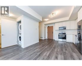 A modern kitchen with white cabinets and a wooden door.