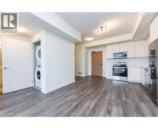 A modern kitchen with white cabinets and a wooden door.