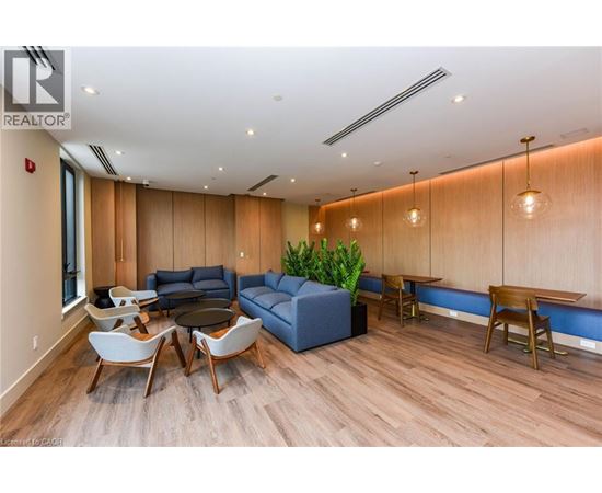 A living room with a blue couch and wooden floors.