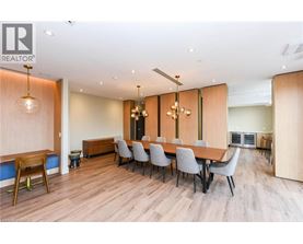 A dining room with a long table and grey chairs.