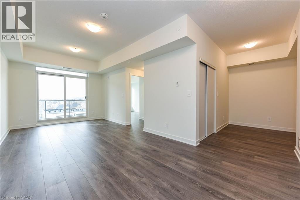 A spacious room with wood flooring and white walls.