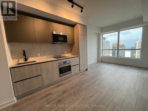 A modern kitchen with wooden cabinets and a large window overlooking the city.