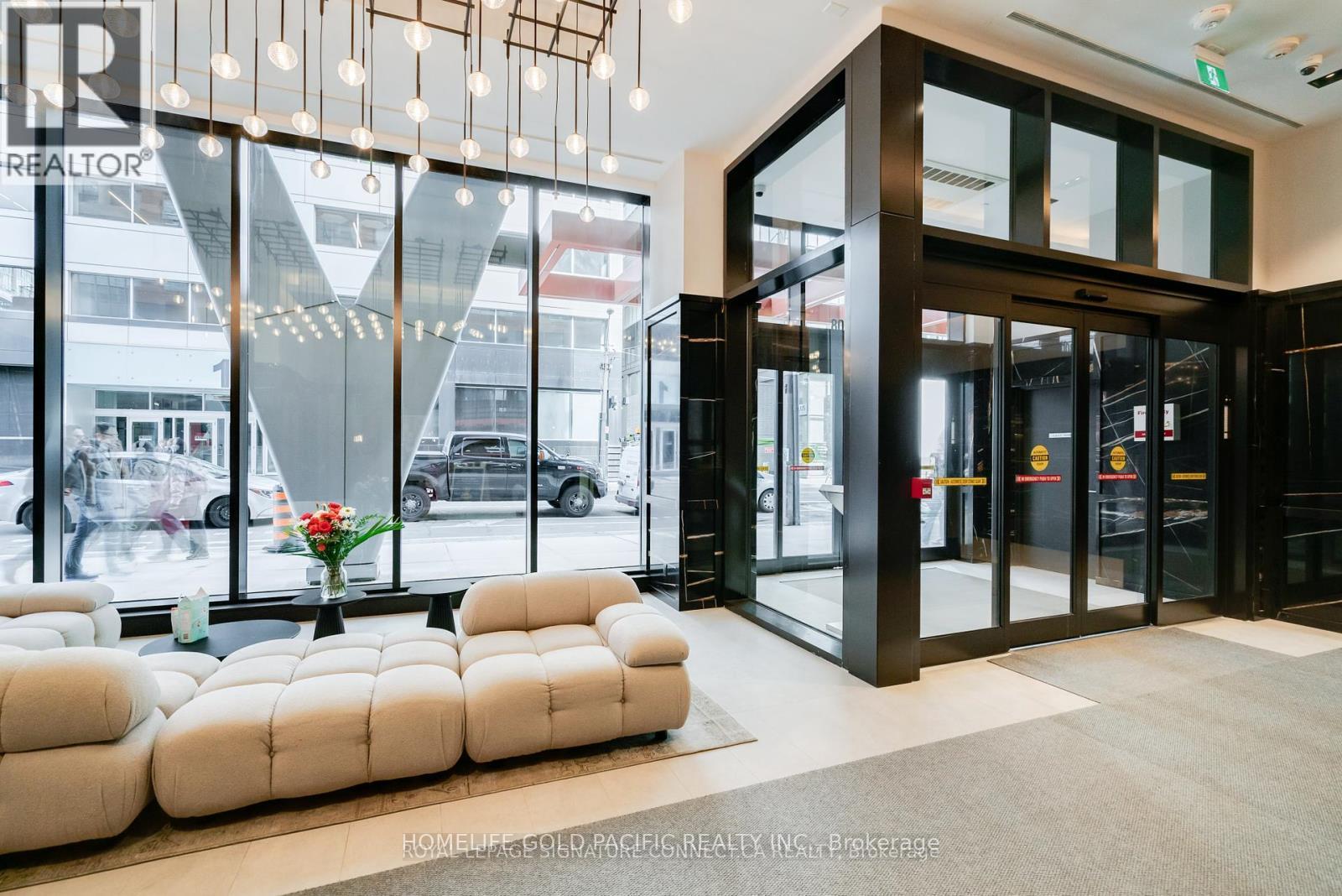 A realtor office with a glass wall and a sofa.