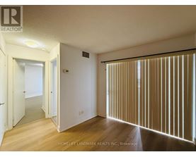 A room with wooden floors and a sliding door with blinds.
