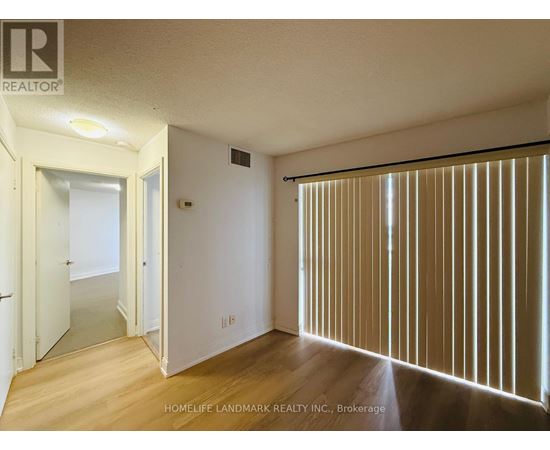 A room with wooden floors and a sliding door with blinds.