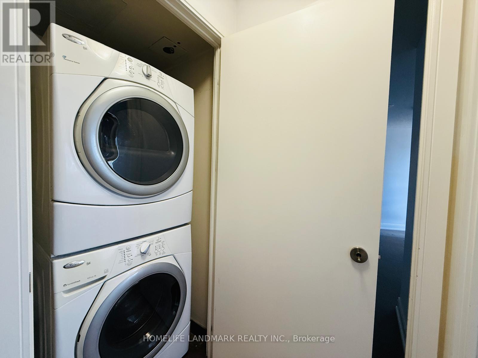 A stack of white front loading washing machines in a small room.