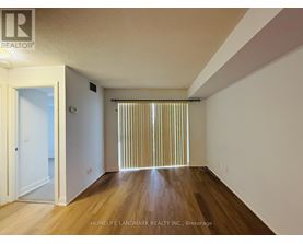 A room with wooden floors and a window with blinds.